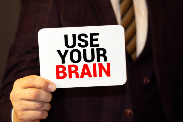 istock Hand holding yellow sticky note written USE YOUR BRAIN word 1277023685