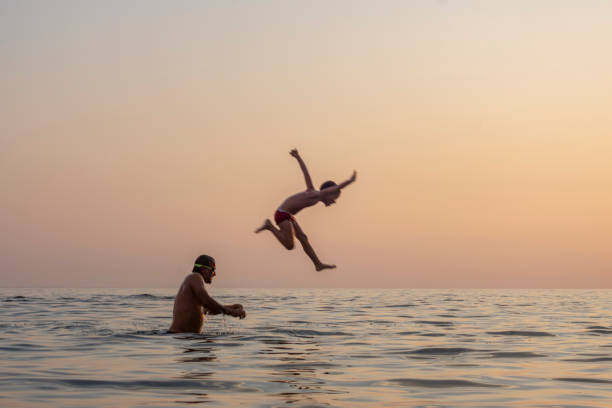 istock The father throws his son into the sea by his shoulder 1277027194