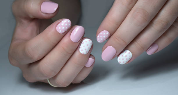 istock Nail design with white dots on pink nail polish 1277027411