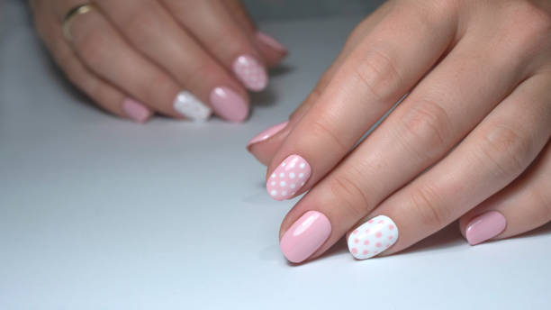istock Nail design with white dots on pink nail polish 1277028128