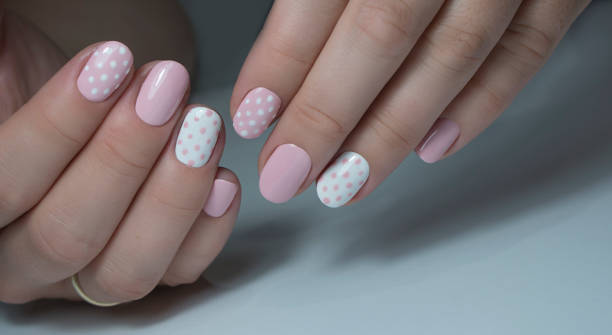 istock Nail design with white dots on pink nail polish 1277028156