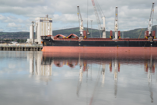 Belfast, Northern Ireland, United Kingdom - August 24, 2020: A bulk carrier unloading its cargo of coal at the Port of Belfast.