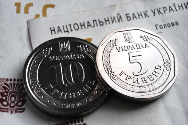 Ukrainian hryvnia coins placed on 100 UAH bills. New type of coins released in 2019 substitute paper notes. stock photo