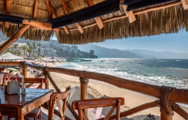 Photo of Restaurants and cafes with ocean views on Playa De Los Muertos beach and pier close to famous Puerto Vallarta Malecon, the city largest public beach