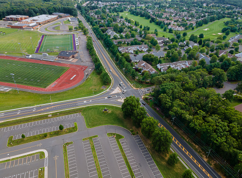 Aerial view of empty stadium with basketball field and training ground along athletic stadium running track in school in the during a pandemic