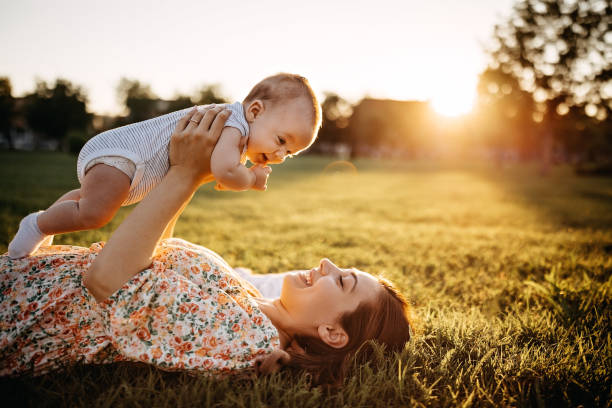 Mother and baby laying down in meadow stock photo