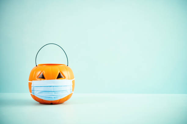 istock Empty Jack O'Lantern Trick or Treat Bucket with Face Mask Halloween Background 1277048721
