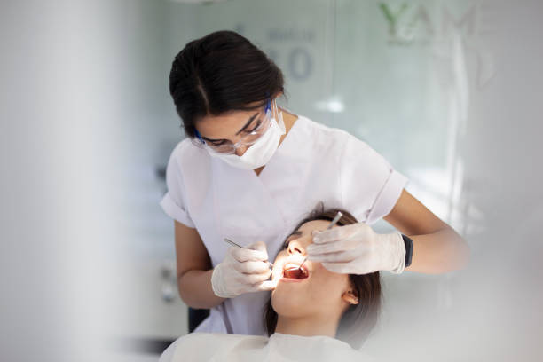 dental hygienist working on young woman's teeth dental hygienist working on young woman's teeth dental hygienist stock pictures, royalty-free photos & images