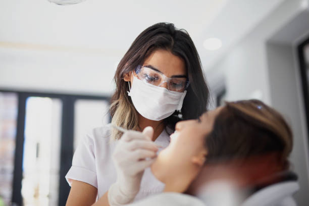 zahnarzt heilt eine patientin - dentist office dental hygiene dentists chair human teeth stock-fotos und bilder