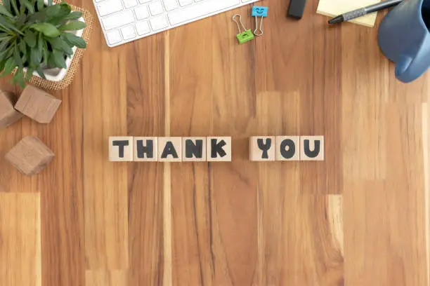 Photo of Thank you, Cubes wooden Lined up into text on the wood desktop vintage white office supplies.