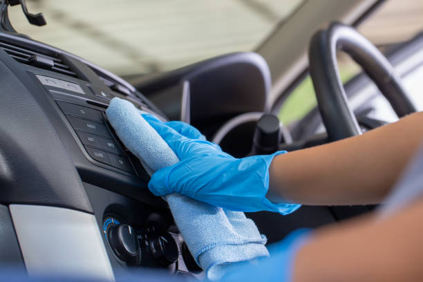 istock Hand wearing rubber gloves and using a blue microfiber cloth clean the car interior. 1277056764