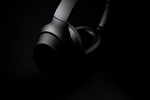 Black headphones on black background.