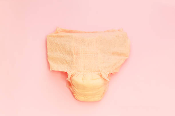 Female diapers on pink background. Disposable underwear for women Female diapers on pink background. Disposable underwear for women. healthy strong medical concept. adult diaper stock pictures, royalty-free photos & images