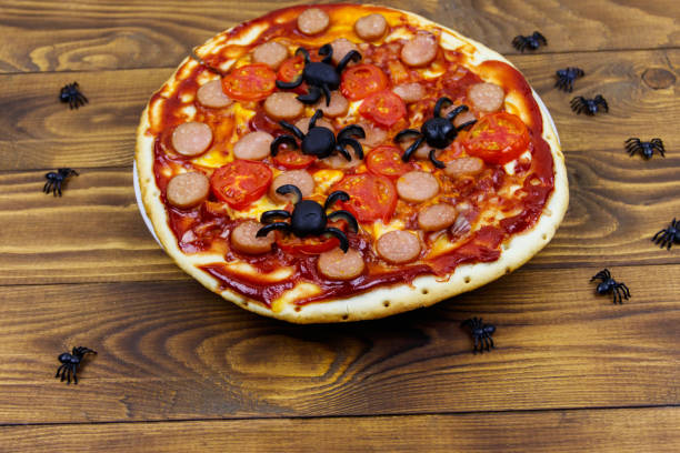 istock Halloween pizza with spiders on wooden table 1277064272