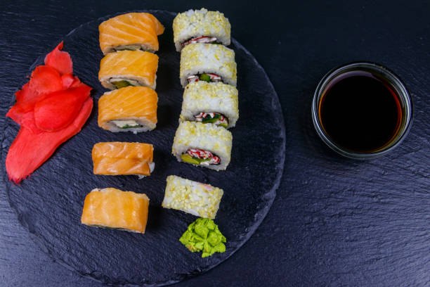 istock Set of sushi rolls on a black stone slate. Top view 1277064516