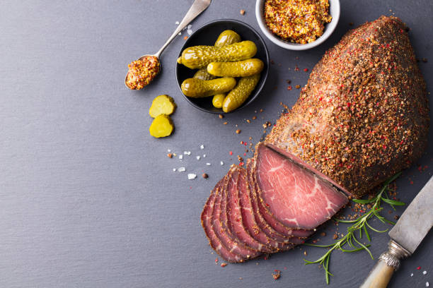 Roasted beef, pastrami on slate cutting board. Copy space. Top view. Roasted beef, pastrami on slate cutting board. Copy space. Top view. pastrami stock pictures, royalty-free photos & images