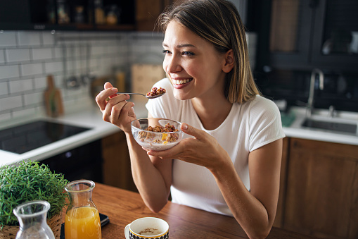 Close up portrait of pretty charming women smiling, enjoying her cereal breakfast