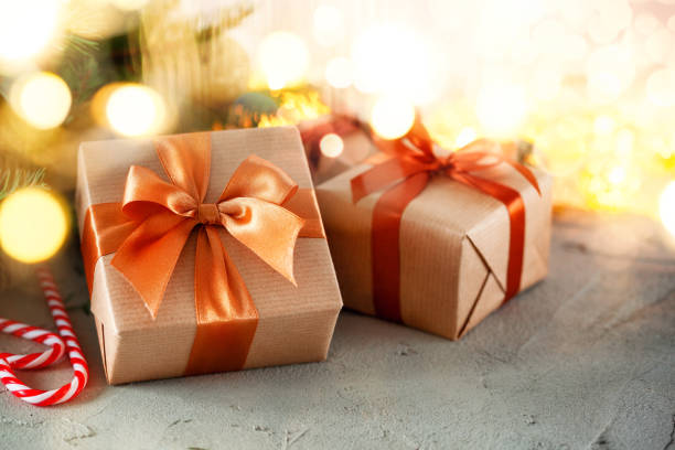 istock Rustic retro gifts, present boxes on bokeh background. Christmas time. Handmade paper wrap. 1277074893