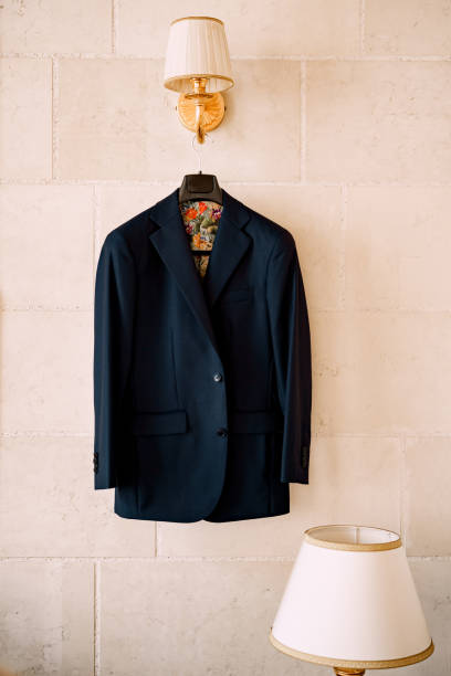 istock A blue jacket with colorful lining on a black hanger hangs from a wall lamp in a room with a table lamp. 1277080710