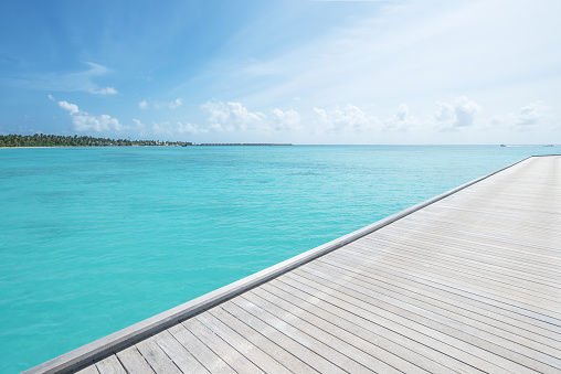 Wooden bridge jetty into the tropical turquoise sea