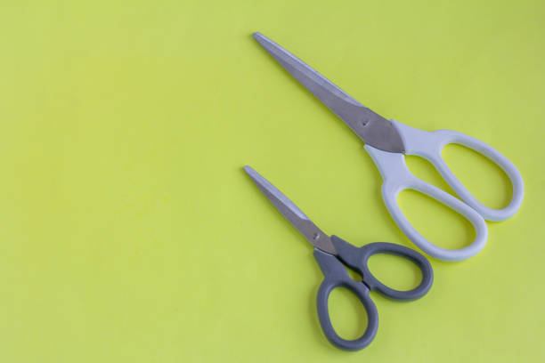 istock Scissors, big scissors and small scissors on a yellow background. White and black scissors with a copy of the space. 1277082349