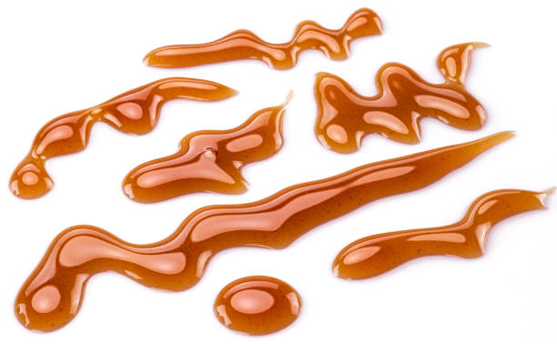 istock Sugar caramel sauce curls isolated on white background. Top view. 1277086431