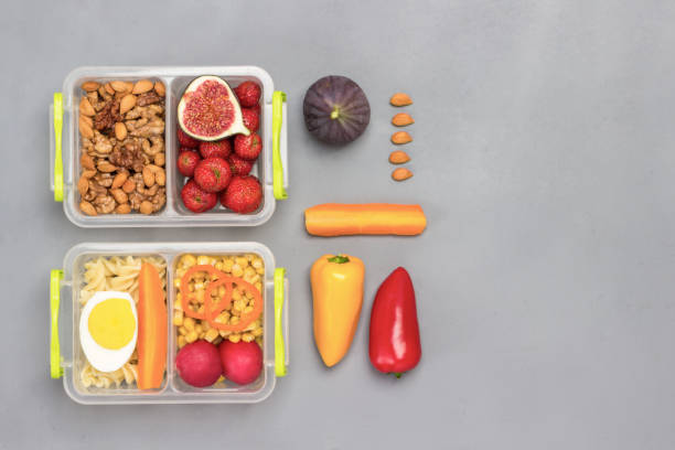 istock School lunch boxes with tasty food. Colored vegetables on table. 1277087212