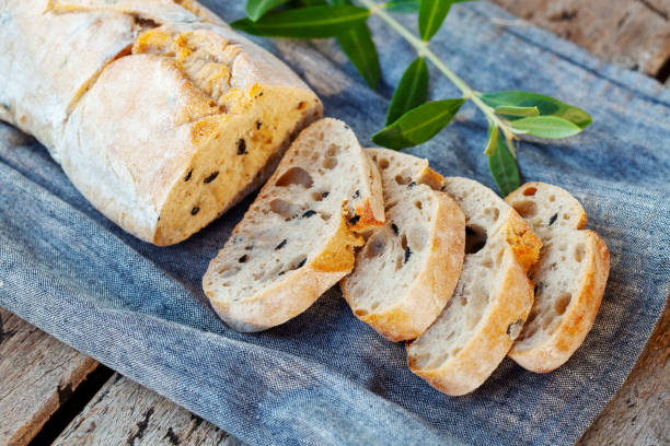 istock Ciabatta bread with olive branch. Wooden background. Close up. 1277088003