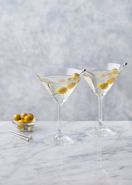 istock Martini cocktail with green olives on marble table background. Copy space. 1277088750