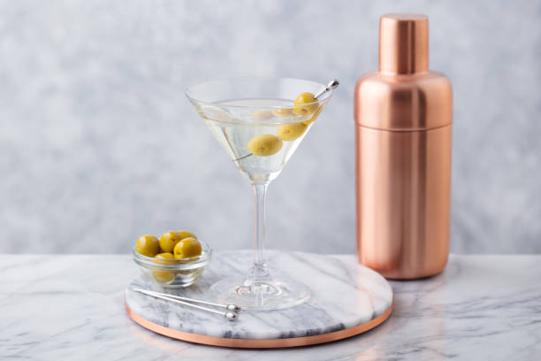 istock Martini cocktail with olives and bar shaker on marble table background. Close up. 1277088768