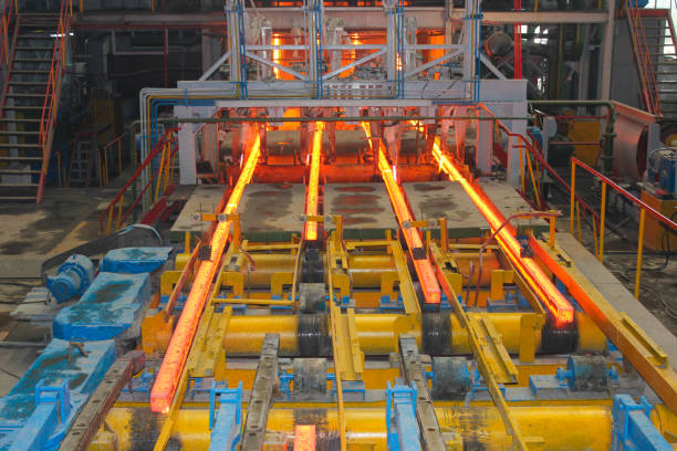 Red hot steel metal billets after molten steel casting.  Continuous casting machine. Background of the blacksmith and metallurgical industry.