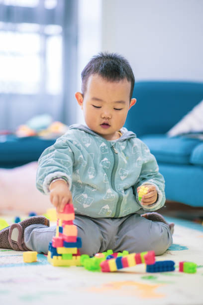 istock Baby boy playing with colorful toy blocks 1277090674