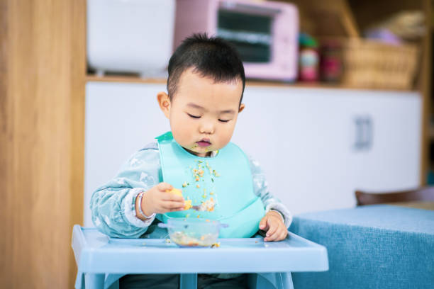 istock baby boy eating food by self 1277090747