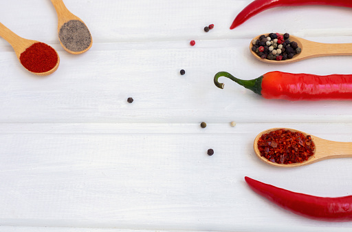 Red hot chili pepper and mix of pepper on a white wooden background. Flatlay, top view