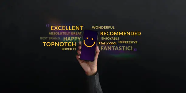 Photo of Customer Experiences Concept. person Raised Up a Mobile Phone with Smiling Face Emoticon. Surrounded by Wordings of Positive Review Feedback. Client Satisfaction Surveys