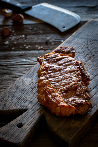 bistecca di striscia alla griglia bistecca di new york su tagliere su legno rustico - strip steak immagine foto e immagini stock