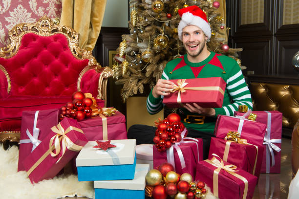 istock Macho in elf costume prepare gift boxes 1277095696