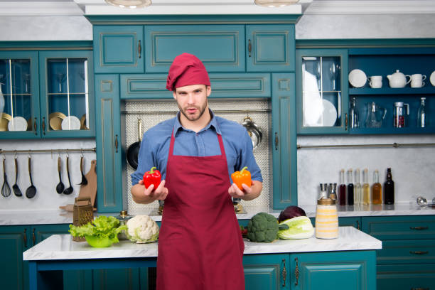 istock Macho in chef hat, apron with red and orange pepper 1277095707