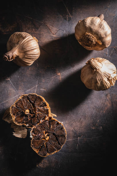 istock Black garlic aged bulbs and cloves on a dark background 1277097149