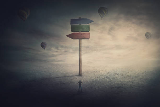istock Surreal scene, tiny man stands in front of a huge signpost with three different directions. Choosing the correct way to unknown future. Courses to left and right side. Road splits, choice concept. 1277097410