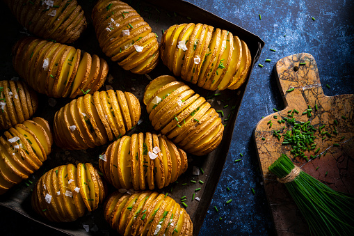 Hassleback potatoes recipe sliced potato oven baked roasted with butter salt and chive herbs garnish