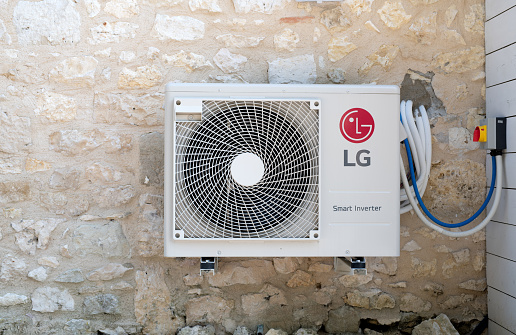 Bergerac, France July 2020: An LG smart inverter mounted on the stone wall of a house