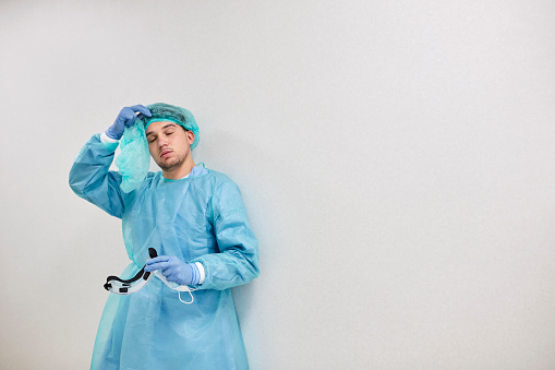 Profesional médico agotado en Blue Coveralls durante la pandemia photo