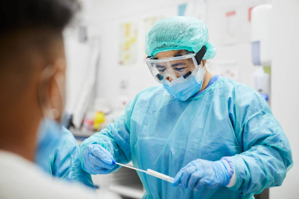 istock Female Doctor Taking Coronavirus Sample From Patient's Nose 1277102922