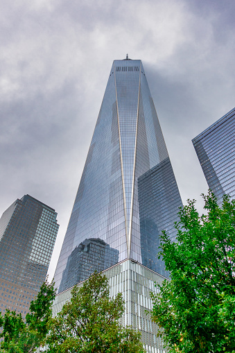New York, NY, USA - June 4, 2022: One World Trade Center, designed by Skidmore, Owings & Merrill (David M. Childs), with clouds reflected on the facade.