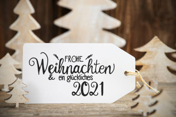 White Christmas Tree, Label, Happy 2021 Means Happy 2021 Label With German Text Frohe Weihnachten Und Ein Glueckliches 2021 Means Merry Christmas And A Happy 2021. White Wooden Christmas Tree As Decoration. Brown Wooden Background german language photos stock pictures, royalty-free photos & images