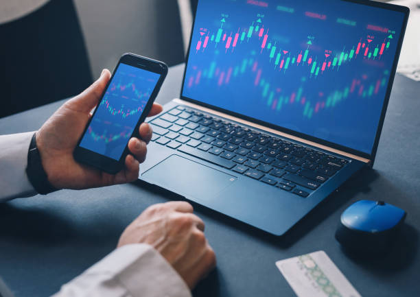 istock Businessman using laptop computer with financial graphs and statistics on monitor. Technical price candlestick chart graph and indicator stock online trading. Forex investment business. 1277104202