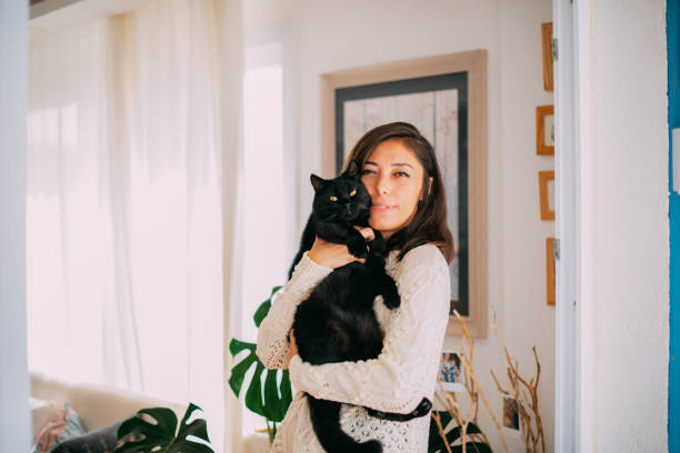 donna carina che abbraccia il suo gatto nero - kitten color image cute feline foto e immagini stock