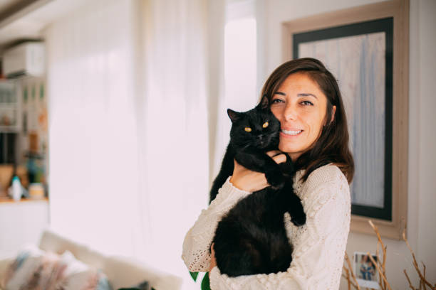 istock Cute Woman Hugging Her Black Cat 1277104335