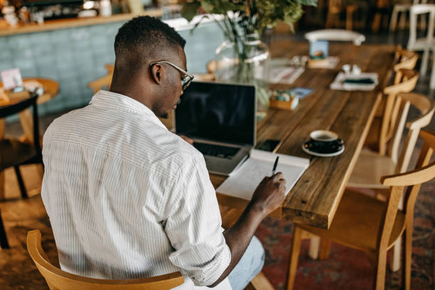 istock Young man sitting in coffee shop and working 1277104920